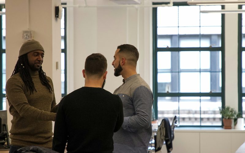 a group of men standing around each other in a room