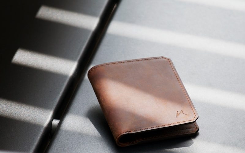 brown leather bifold wallet on white and black striped surface